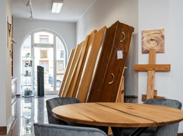 Ausstellungsraum mit Särgen und Beratungsbereich