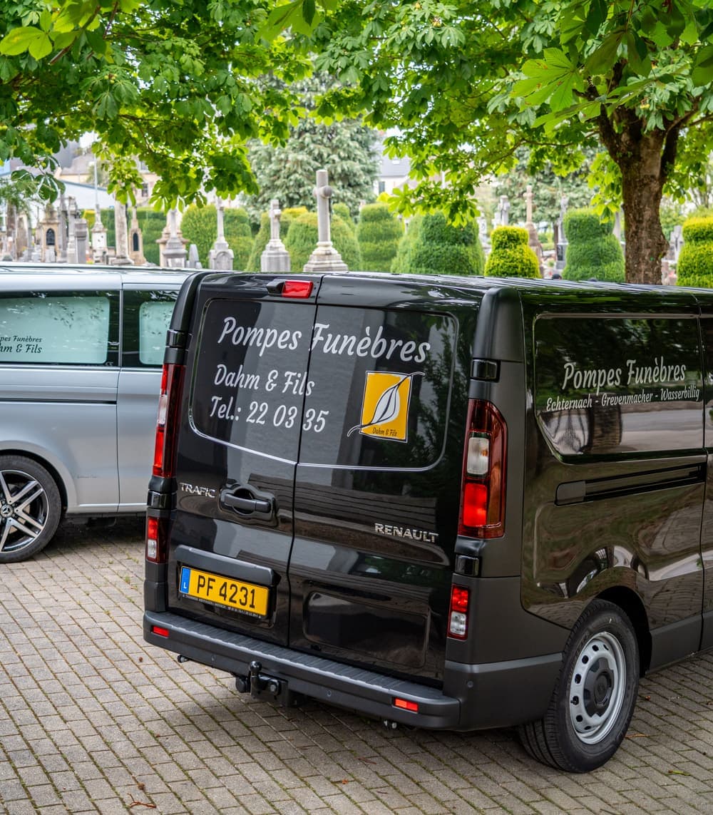 Bestattungsfahrzeug von Dahm & Fils vor einem Friedhof